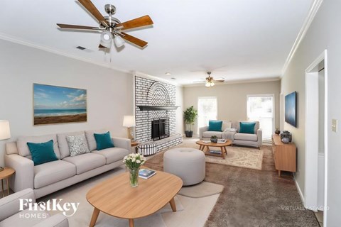 A living room with a grey couch, a coffee table, and a painting on the wall.
