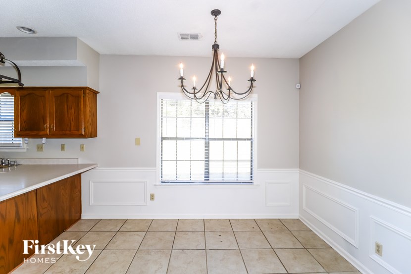 A kitchen with wooden cabinets and a chandelier.