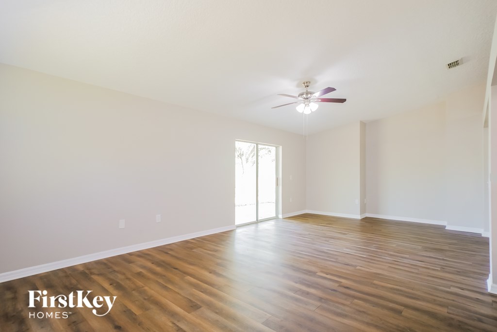 A room with wooden floors and a ceiling fan.