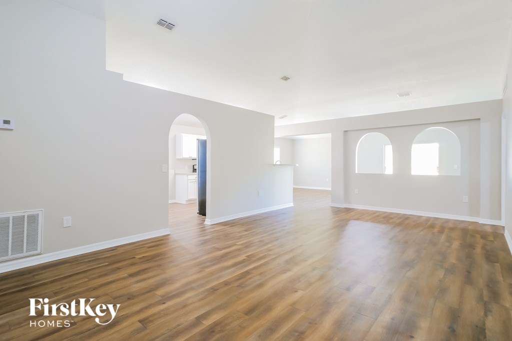 A spacious room with wooden floors and white walls.