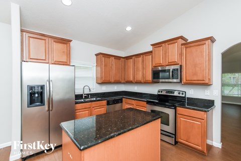 A kitchen with wooden cabinets and a black countertop.