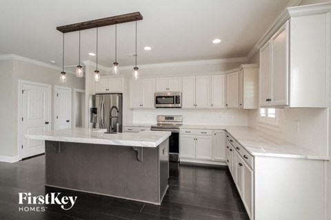a large white kitchen with white cabinets and stainless steel appliances