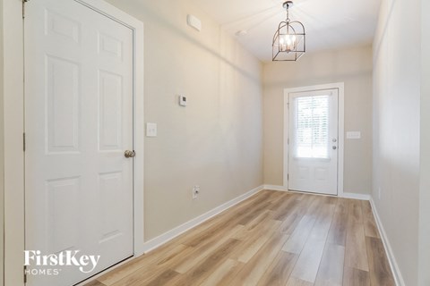 an empty room with a white door and a light fixture