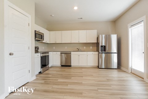a kitchen with white cabinets and a stainless steel refrigerator
