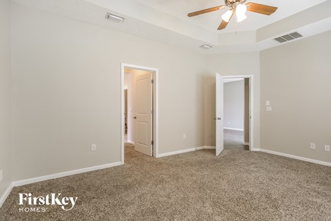 a living room with carpet and a ceiling fan