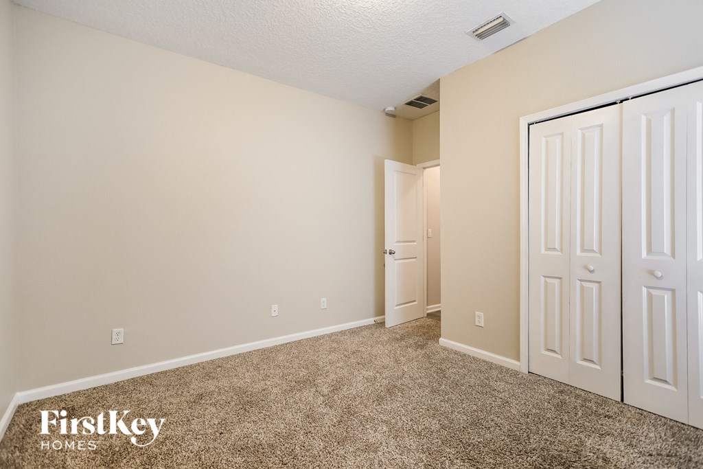 a bedroom with two closets and a door to a hallway