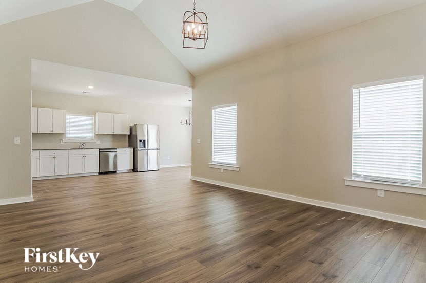 the living room and kitchen of an empty house