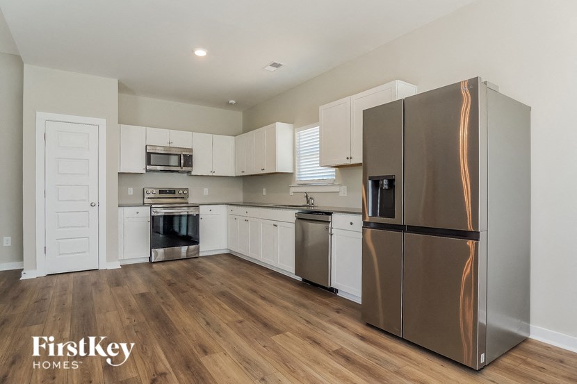 a kitchen with white cabinets and stainless steel appliances