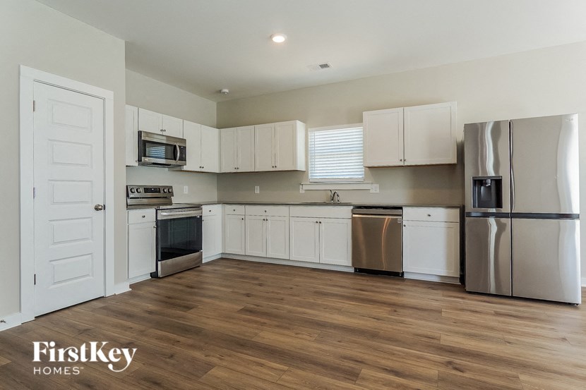 a white kitchen with stainless steel appliances and white cabinets