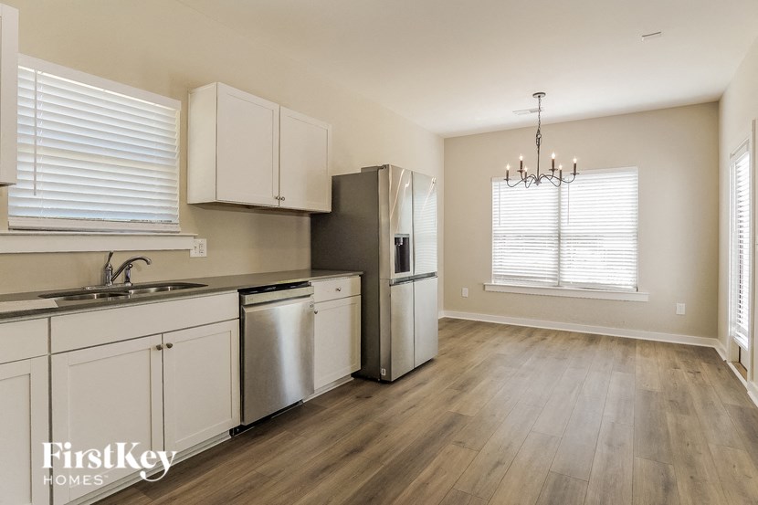 a kitchen with white cabinets and a stainless steel refrigerator