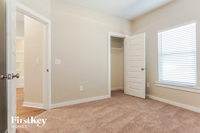 a bedroom with a closet and an open door and a window