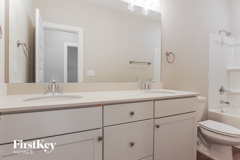 a bathroom with two sinks and a mirror and a toilet
