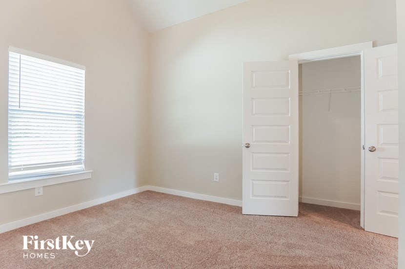 a bedroom with a closet and a window and an open door