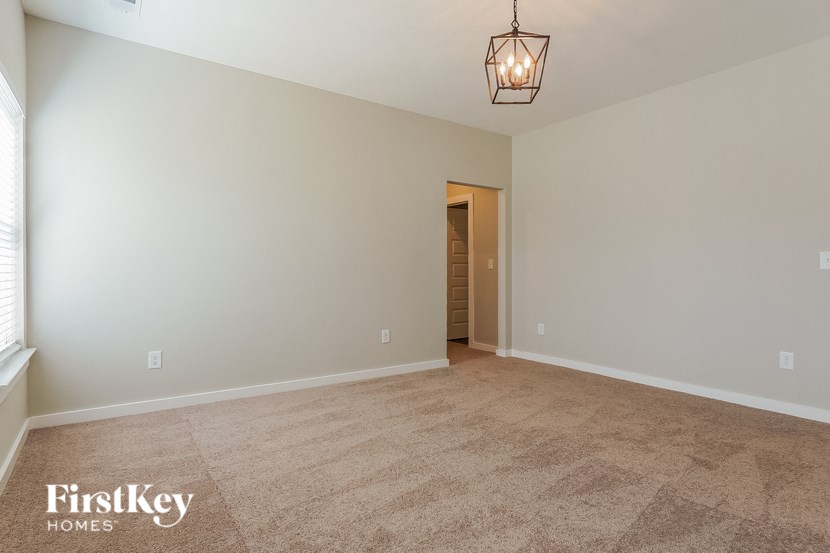 the spacious living room with carpeting and a light fixture
