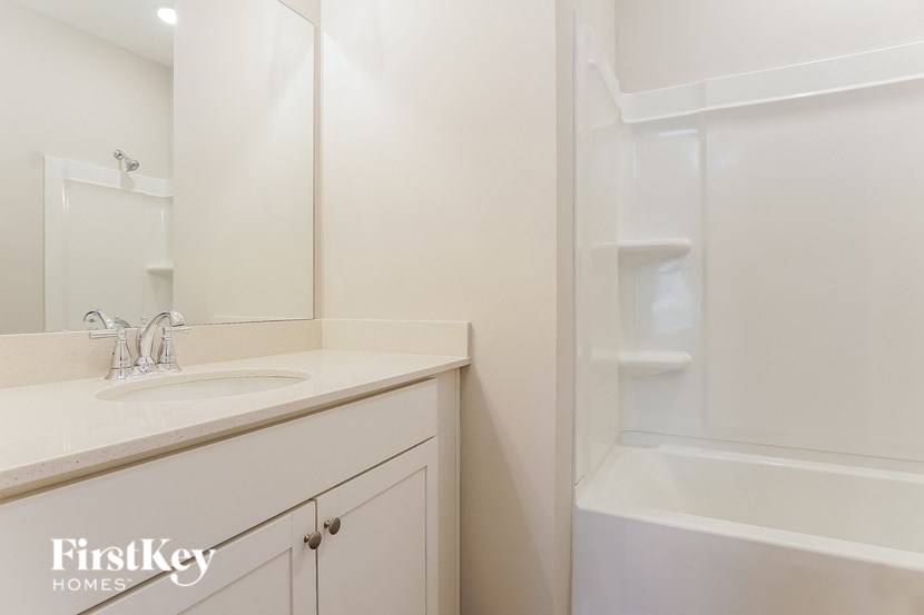 a bathroom with a sink and a shower and a mirror