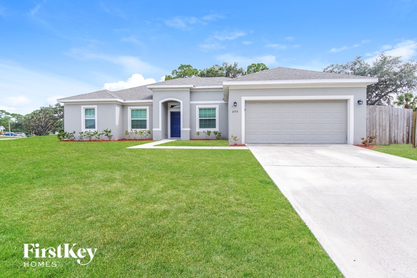 A house with a garage and a driveway in front of it.