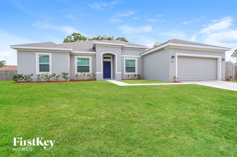 A house with a blue door and a garage is for sale.