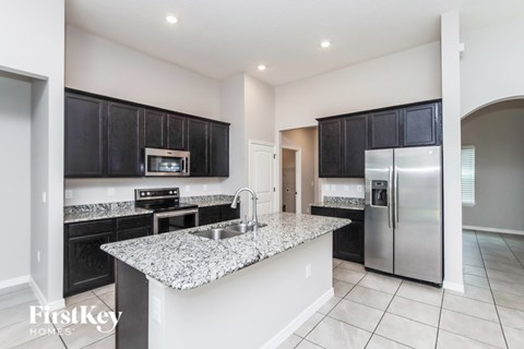 A kitchen with granite countertops and stainless steel appliances.