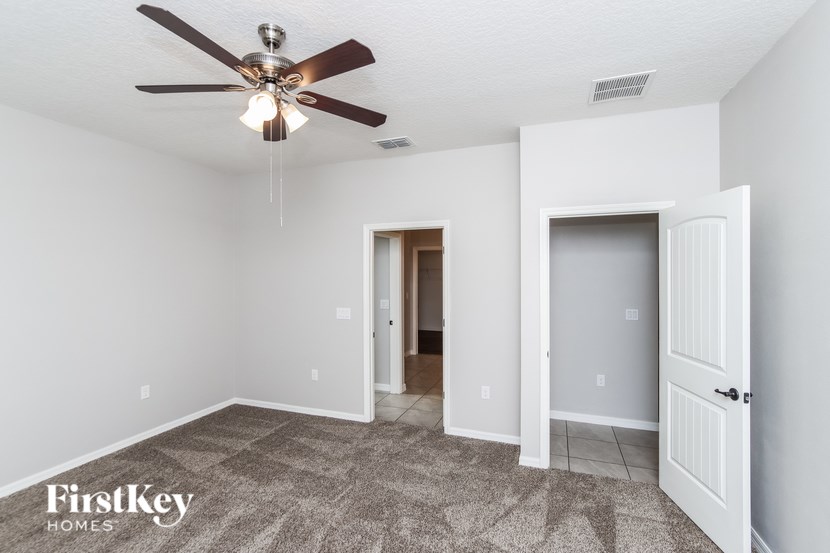 A room with a ceiling fan and a carpeted floor.
