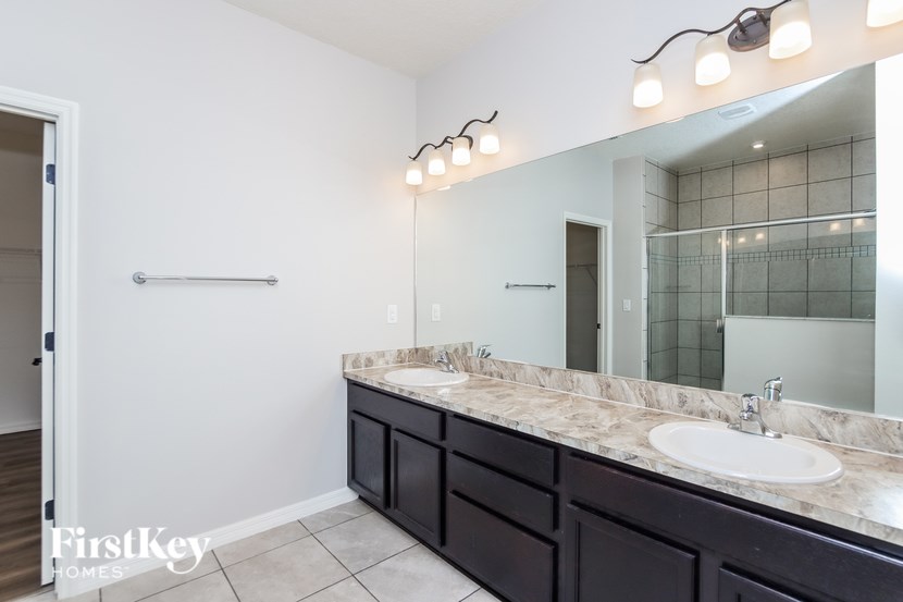 A bathroom with a marble countertop and a large mirror.