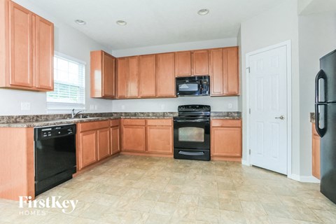 a kitchen with wooden cabinets and black appliances