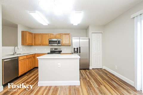 A kitchen with wooden cabinets and a white island.