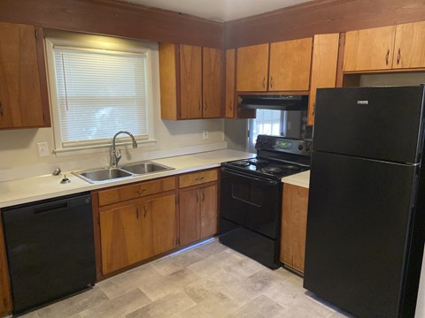 a kitchen with black appliances and wooden cabinets