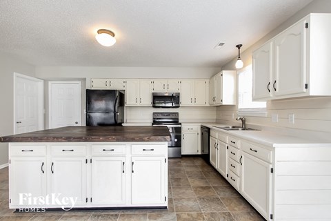 A kitchen with white cabinets and appliances.