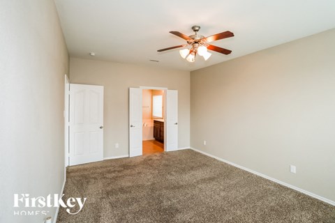 a living room with carpet and a ceiling fan