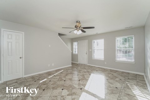 A spacious room with a fan and tiled flooring.