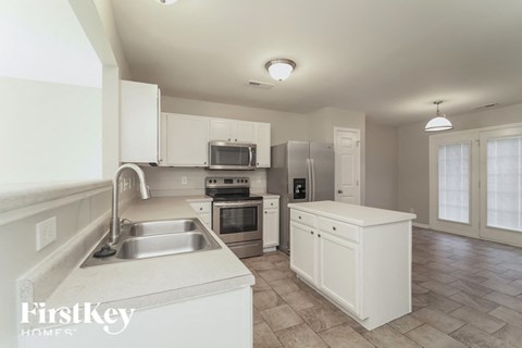 A kitchen with white cabinets and a stainless steel sink.