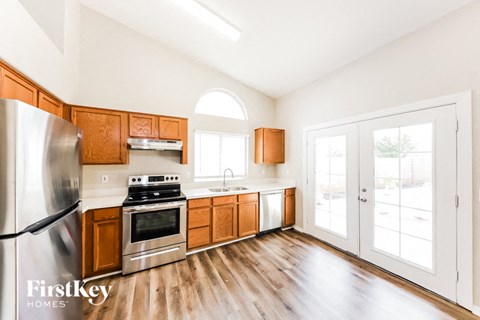 A kitchen with wooden cabinets and a stainless steel refrigerator.