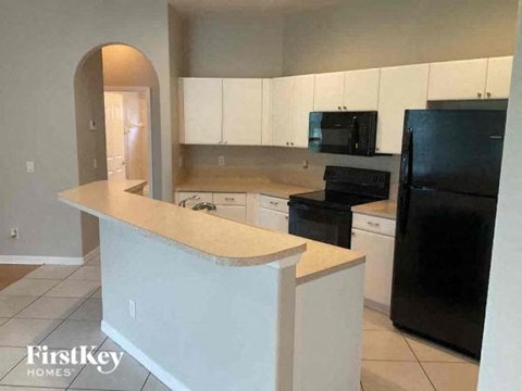 a kitchen with a counter and a black refrigerator