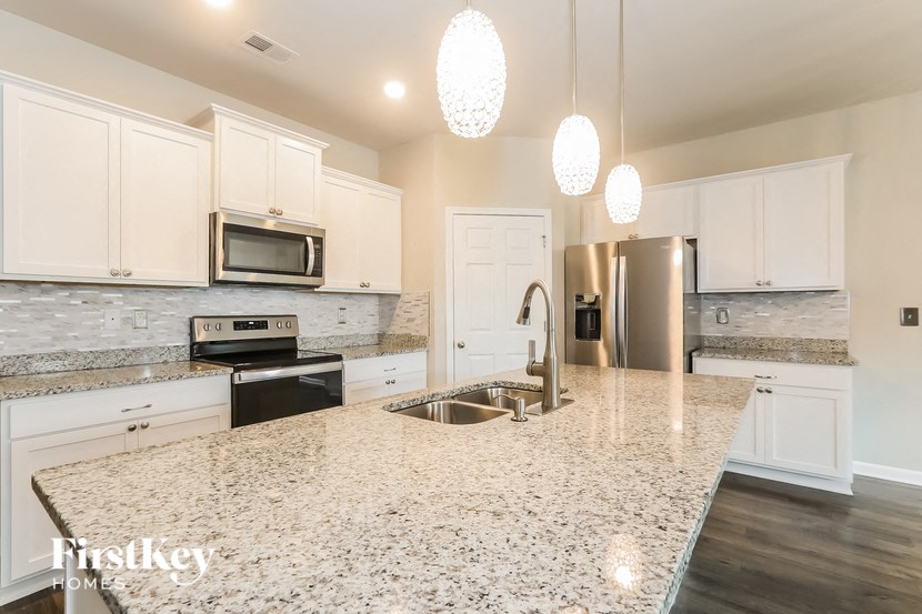 a kitchen with white cabinets and a granite counter top