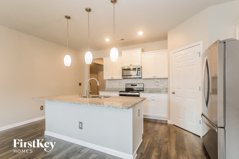 a kitchen with white cabinets and a marble counter top
