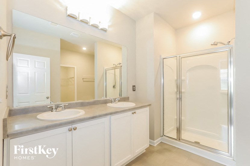a bathroom with two sinks and a shower