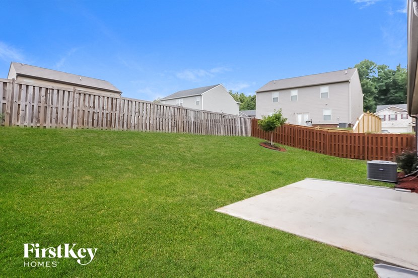 a backyard with a wooden fence and a yard with green grass