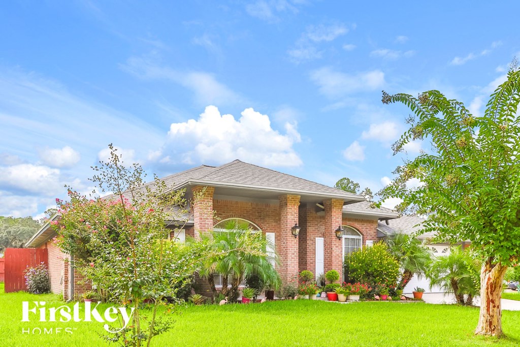 side view of a house with green grass and trees