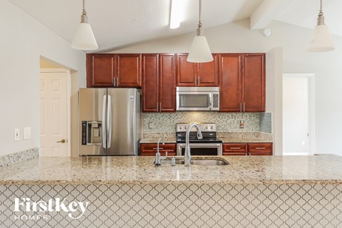 a kitchen with wooden cabinets and a marble counter top