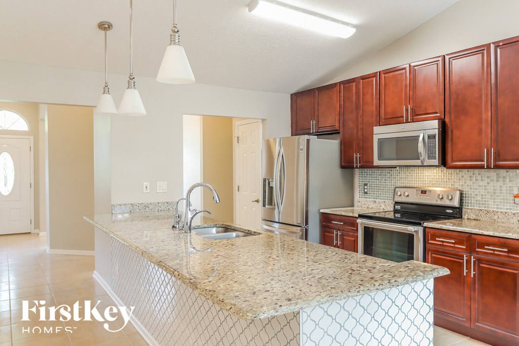 a kitchen with granite counter tops and wooden cabinets