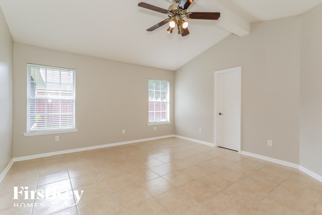 an empty living room with a ceiling fan