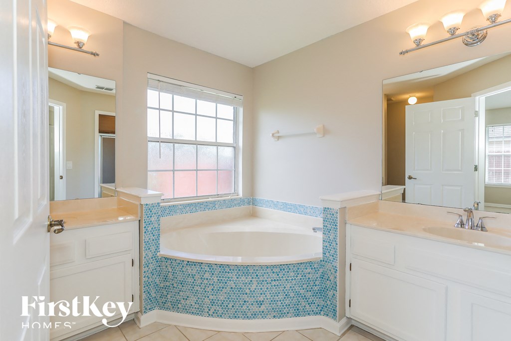 a bathroom with a large tub and two sinks