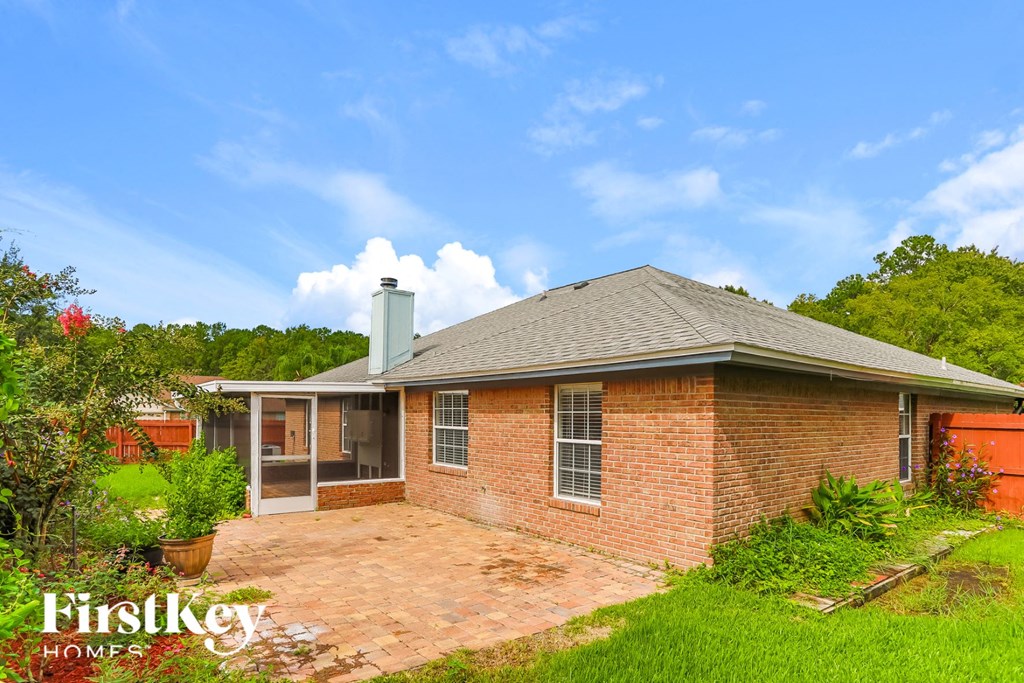 the backyard of a brick house with a brick patio