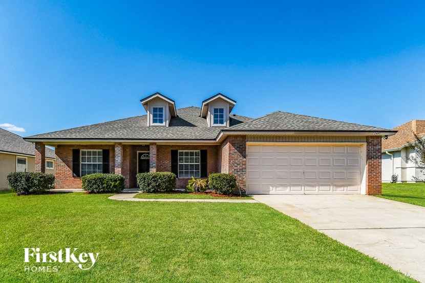 a home with a garage door and a lawn