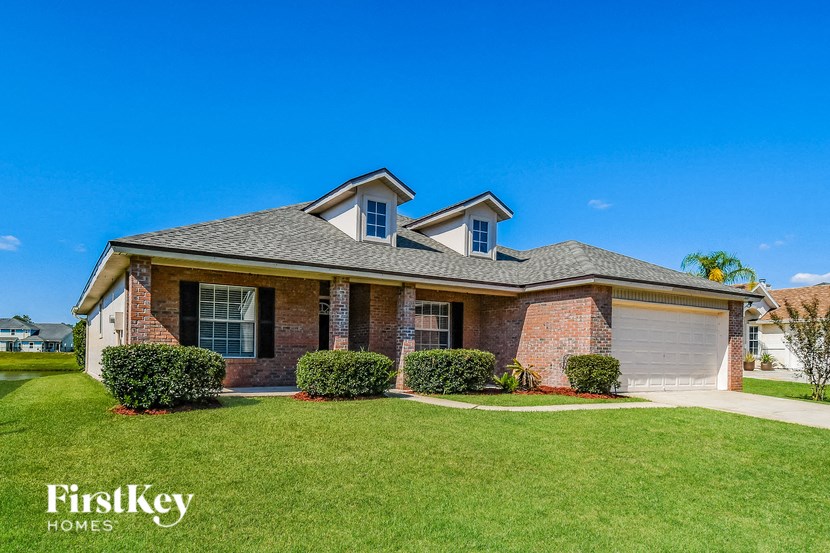 a brick house with a lawn and a blue sky
