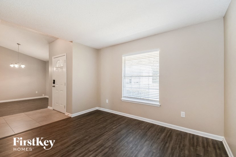 an empty living room with wood flooring and a white door