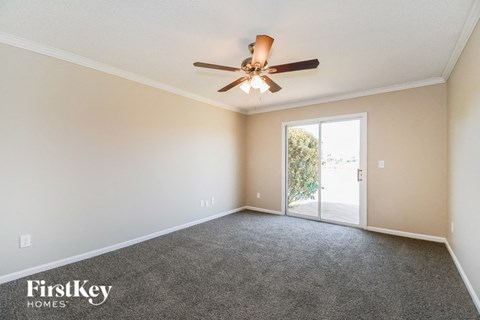 a living room with carpet and a ceiling fan