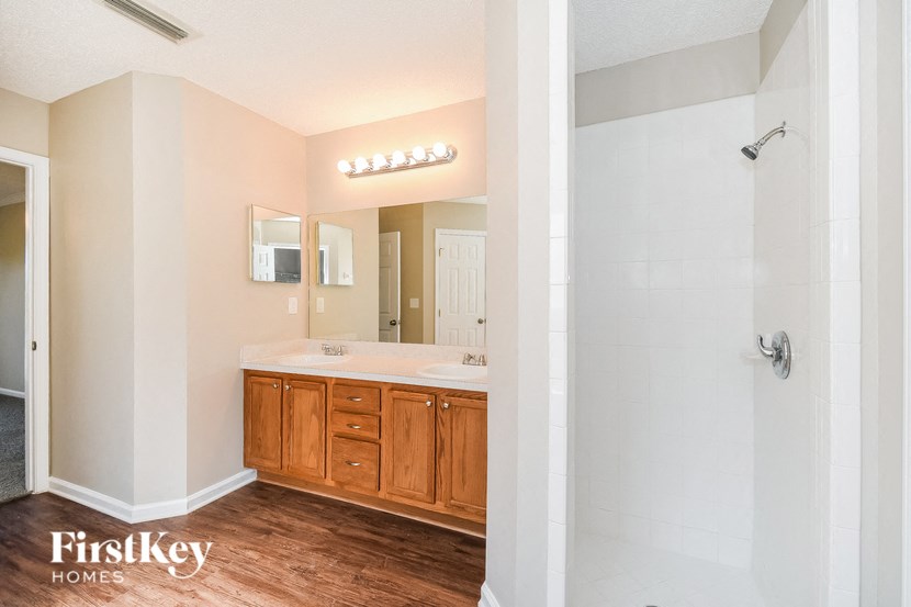 a bathroom with a shower and a sink and a mirror