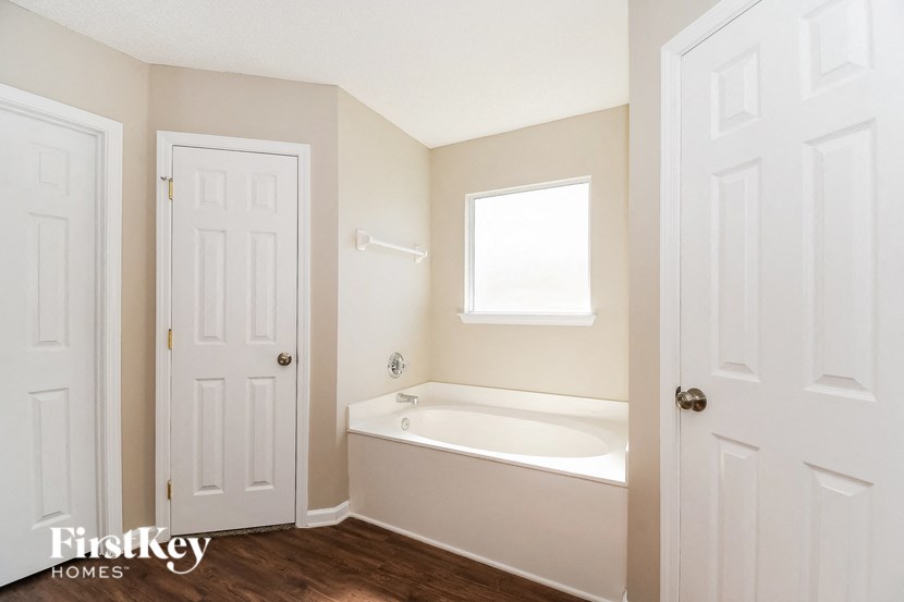a small bathroom with a tub and a white door