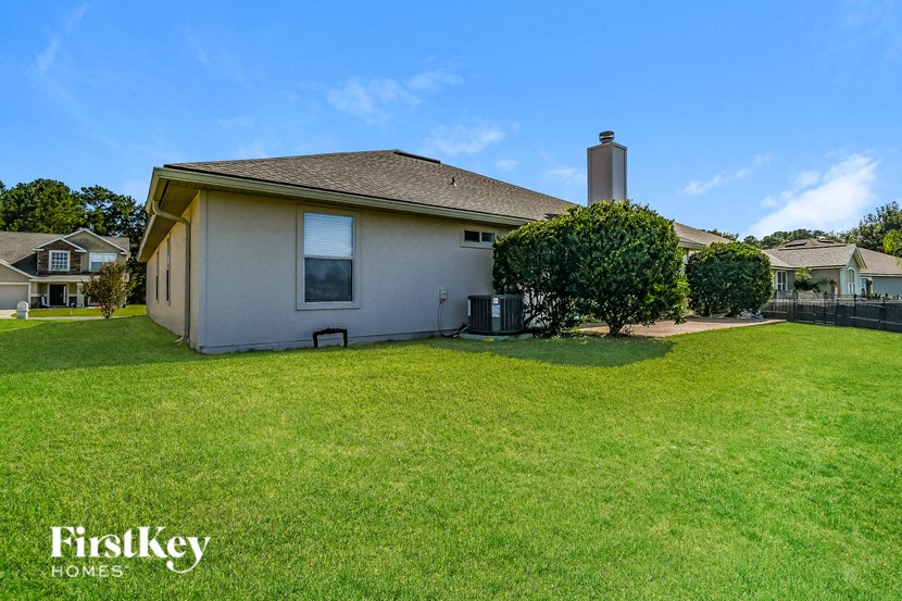 a white house with a yard and a green lawn